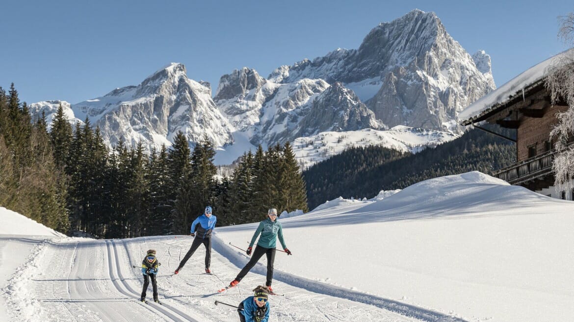 Rodina lyžuje na slunečné běžecké trati ve Filzmoosu