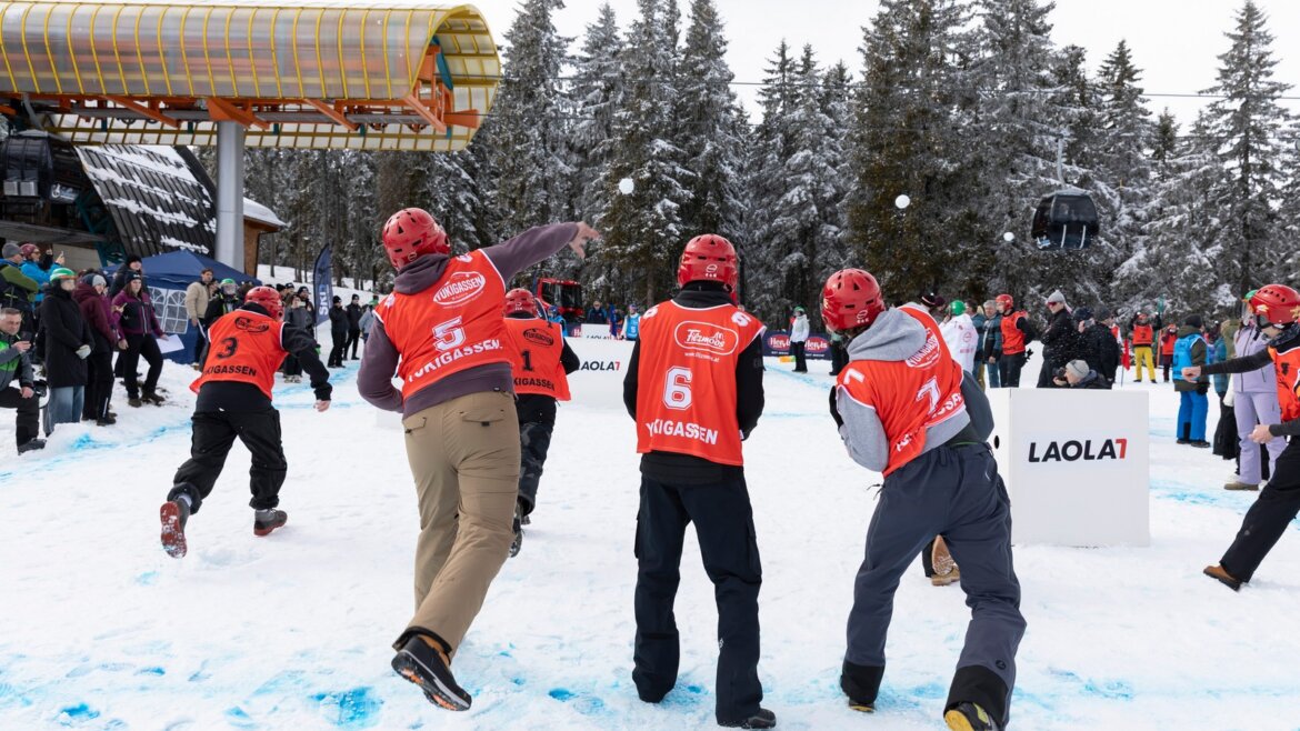 Yukigassen je týmová sněhová bitva podle japonských pravidel © Tourismusverband Filzmoos, Andrew Phelps Tři hráči v červených dresech během zápasu Yukigassen na zasněženém hřišti ve Filzmoosu (Zvětšený pohled)