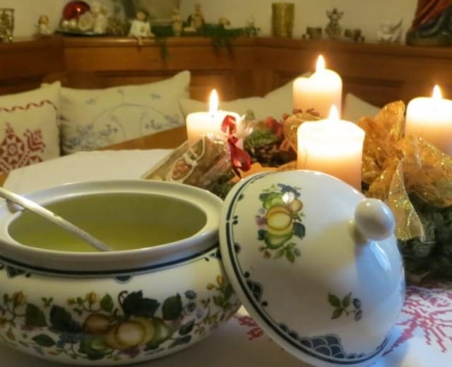 img_5164-1280×1024-1-1280×658 Štědrovečerní vývar z hovězího masa se zeleninou, uzeninami a nudlemi servírovaný v malované porcelánové míse, zatímco na stole hoří na adventním věnci všechny čtyři svíčky.