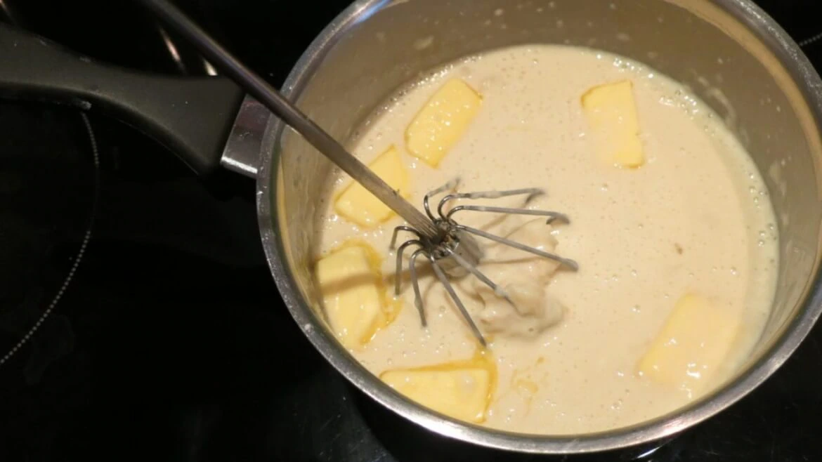 V hrnci se zahřívá mléko s moukou, do kterého pak přijde na kostičky nakrájené změklé máslo.
