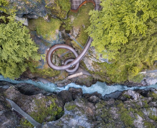 Letecký pohled na soutěsku Liechtensteinklamm s řekou v St. Johann turistika, orámovanou skalami a svěžími zelenými stromy.