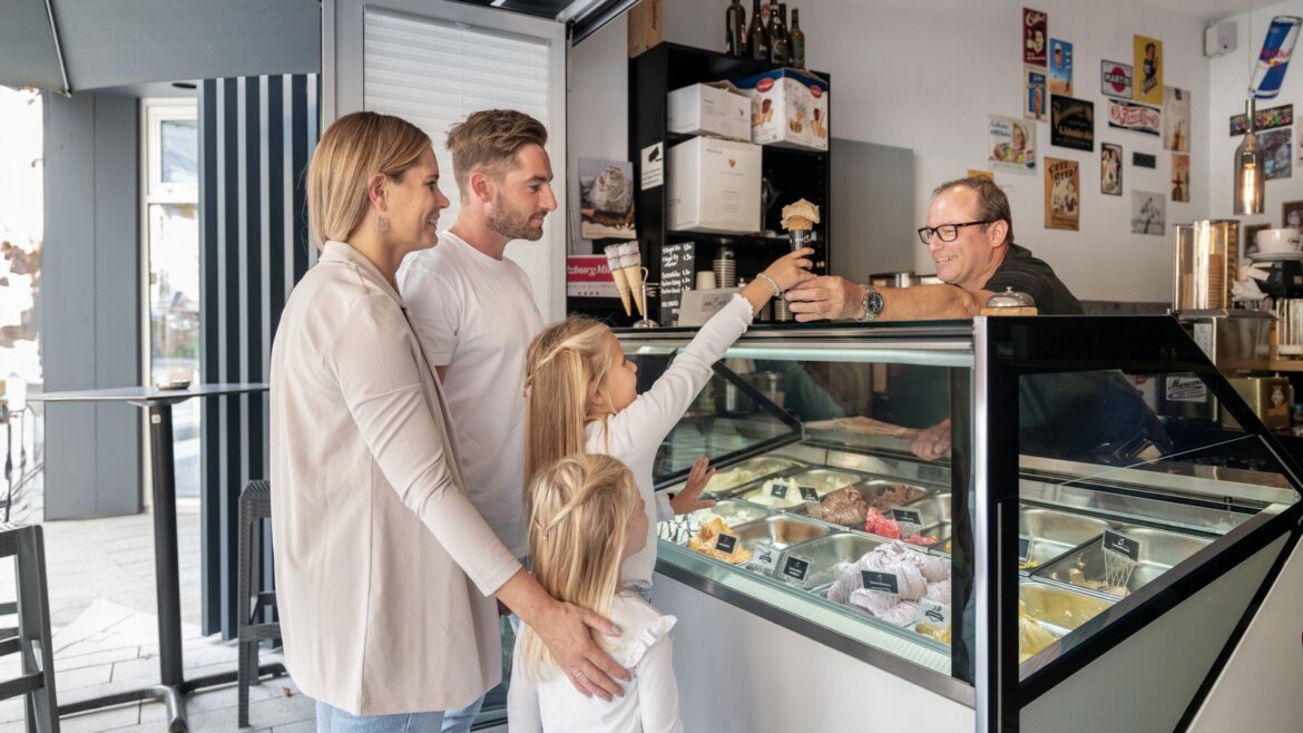 Rodina ve zmrzlinárně v St. Johann v Salcbursku si pochutnává na zmrzlině po sportovních zážitcích. (Zvětšený pohled)