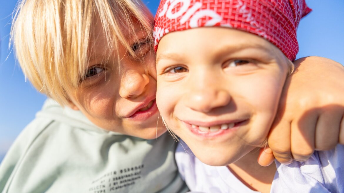 Turistika ve Flachau se líbí i dětem © Flachau Tourismus, Markus Berger Dvě usměvavé děti s červeným šátkem pózují venku ve Flachau turistika pod jasně modrou oblohou. (Zvětšený pohled)