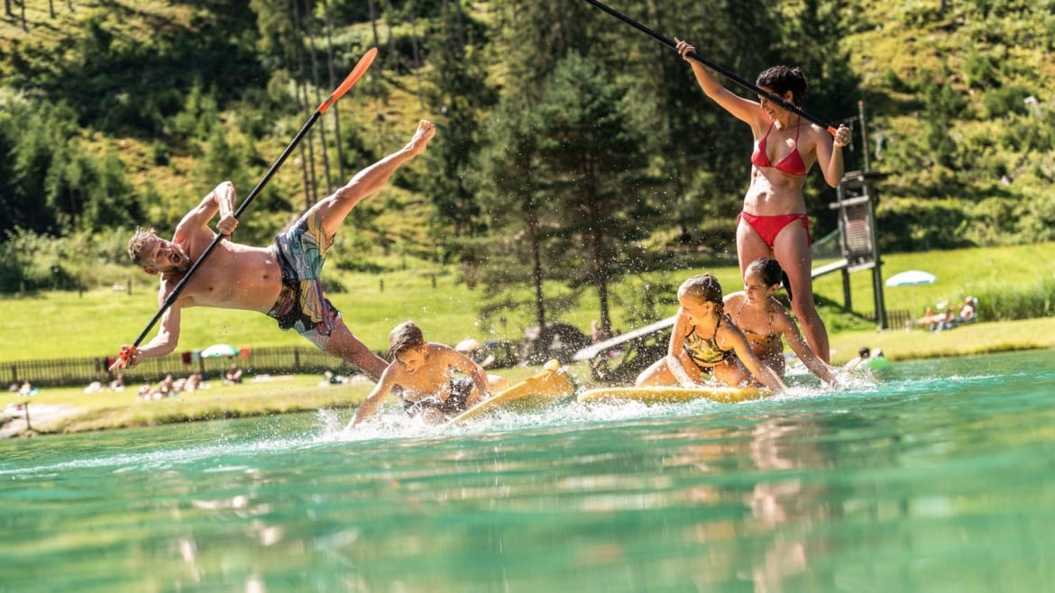 Rodina na paddleboardu na koupacím jezeře ve Flachau