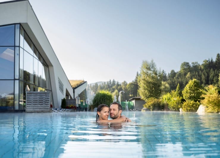 Pár se objímá ve vodě jednoho z bazénů v termálních lázních Erlebnis-Therme Amadé v Altenmarkt-Zauchensee