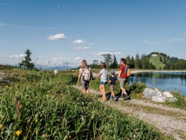 Familienwanderung-Speicherteich-Alpendorf Rodina na výletě u nádrže v horách v oblasti Alpendorf v St. Johann v Salcbursku