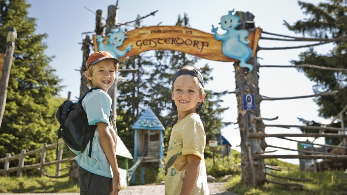 Děti u vstupu do zážitkového, dobrodružného areálu Geisterberg na hoře Gernkogel.