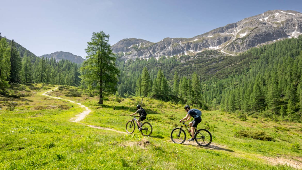 Dvojice jede krásnou přírodou uprostřed hor na kolech na Tauernkarleitenalm