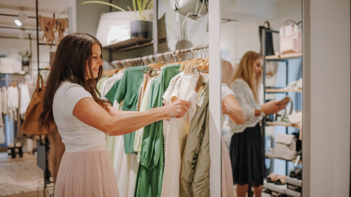 Žena si prohlíží oblečení v moderním butiku v Altenmarkt-Zauchensee