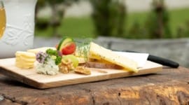 Dřevěné prkénko obložené sýry, sýry a zeleninou ochutnáte na kulinářských výletech v Gasteinu