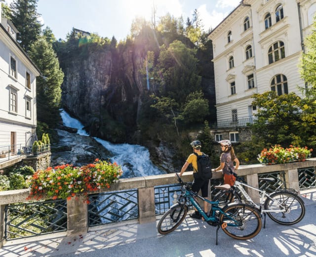 Alpe Adria Radweg Cyklisté pozorují z mostu mohutný vodopád v centru města Bad Gastein