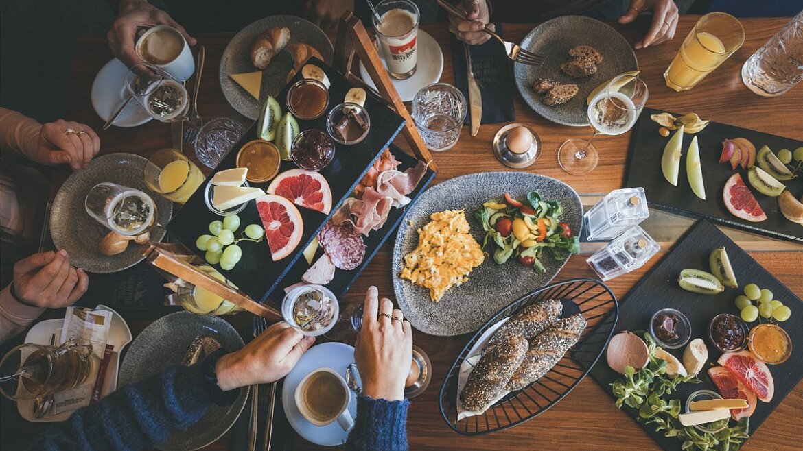 Bohatě prostřený stůl s ovocem, vejci, pečivem a kávou. Brunch v Saalbachu Hinterglemmu