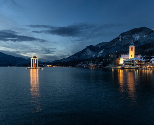 Jezero Wolfgangsee s poutním kostelem a plovoucí lucernou míru