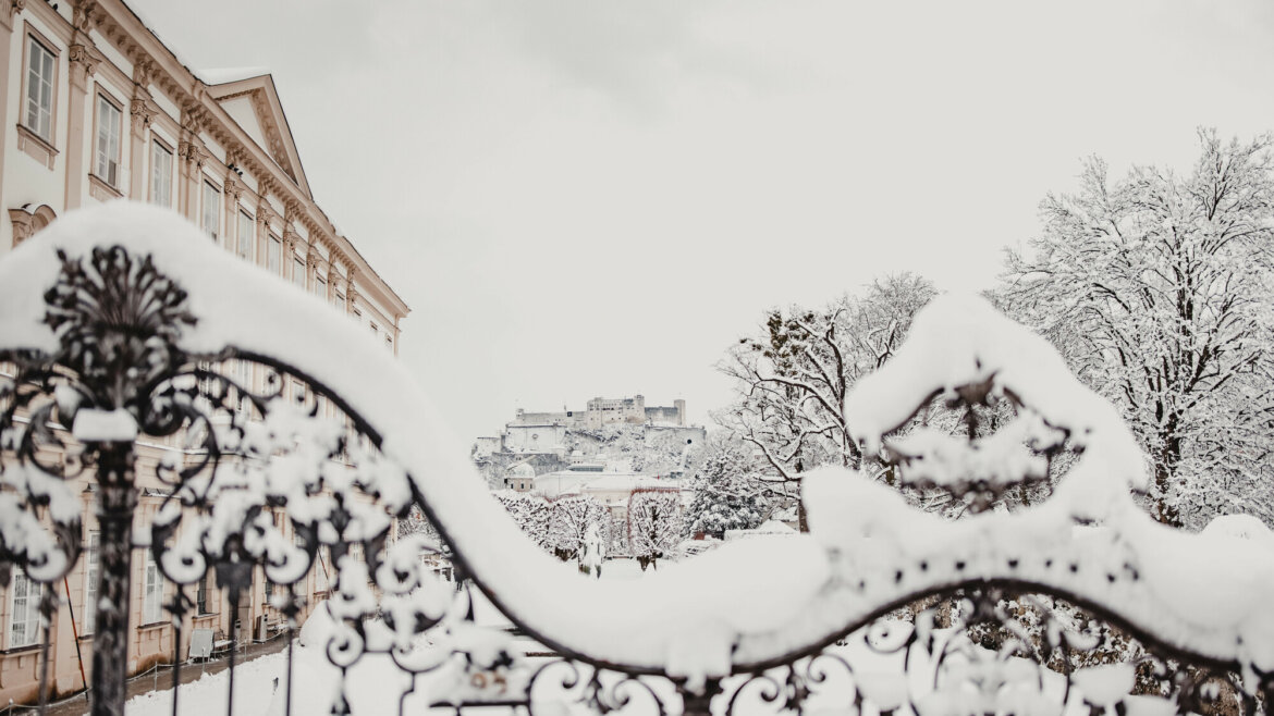 Zasněžené zahrady Mirabellgarten s výhledem na pevnost Hohensalzburg