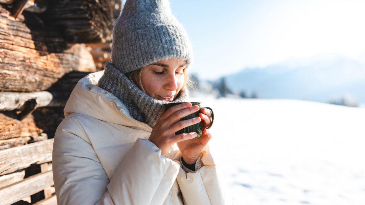 Šálek horkého nápoje na čerstvém vzduchu v zasněžené krajině Národního parku