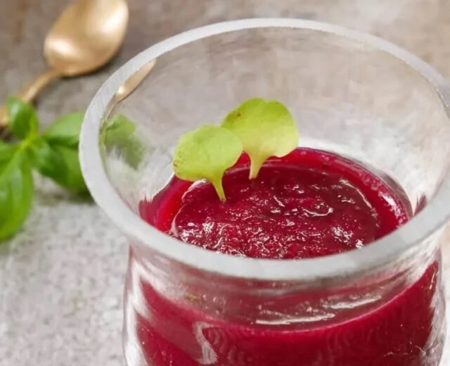 Rote-Rüben-Smoothie_SAMk Zdravé a zářivě červené smoothie z červené řepy ve sklenici ozdobené zelenými lístky