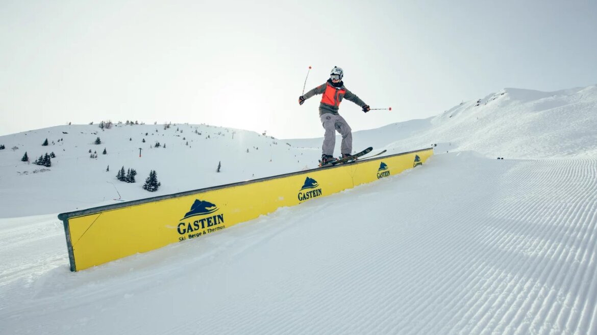 Jezdec na zábradlí jede freestyle ve snowparku v Gasteinu