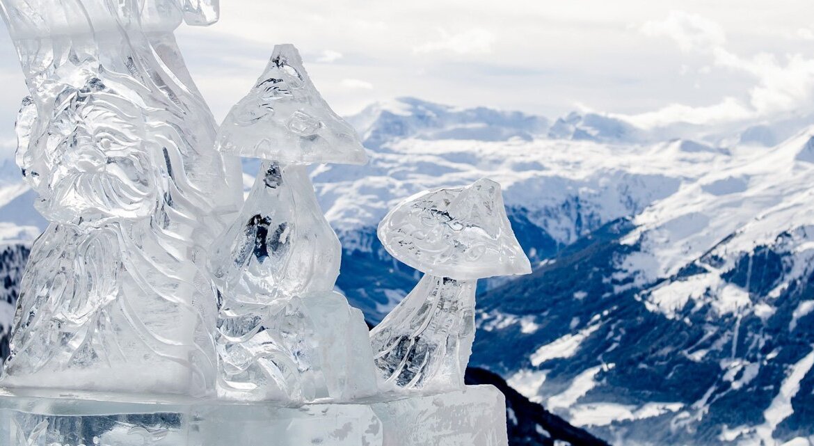 Socha z ledu v podobě křišťálově se třpytících hub na festivalu Art on snow a výhled na zasněžené hory okolo Gasteinu