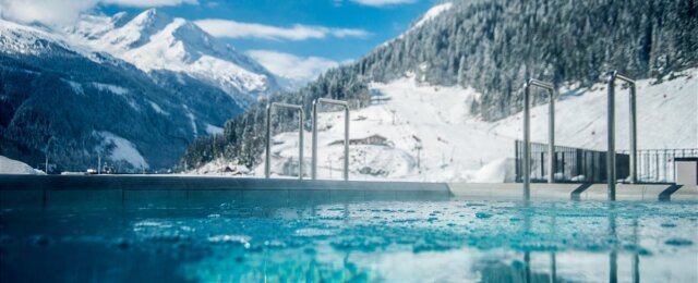 Ve venkovním bazénu lázní Felsentherme Bad Gastein je i v zimě příjemně teplá termální voda