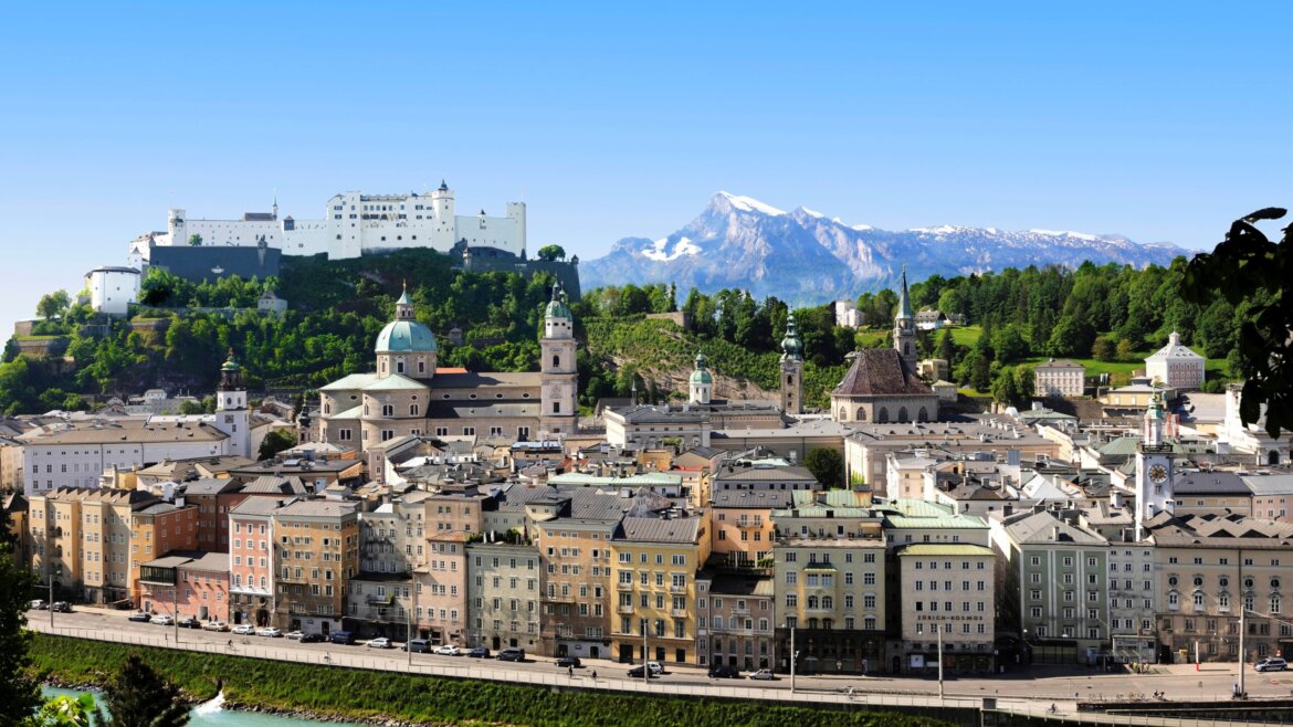 Panoramatický pohled na Salcburk s pevností Hohensalzburg, historickými budovami a horami v pozadí. (Zvětšený pohled)