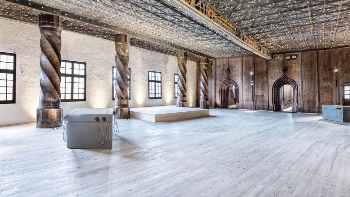 Knížecí prostory na pevnosti Hohensalzburg © Salzburger Burgen & Schlösser Prostorný sál se zdobeným stropem, sloupy a klenutými dveřmi v pevnosti Hohensalzburg (Zvětšený pohled)