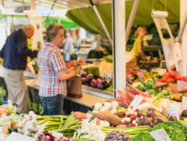 Maerkte_Schranne-210-1600×550 Lidé nakupující čerstvou zeleninu na venkovním farmářském trhu – ideální pro letní recepty ze Salcburska.