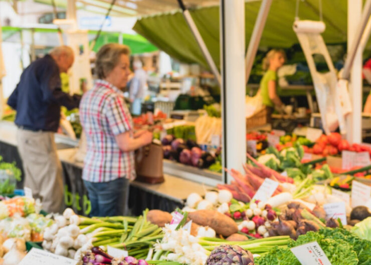 Maerkte_Schranne-210-1600×550 Lidé nakupující čerstvou zeleninu na venkovním farmářském trhu – ideální pro letní recepty ze Salcburska.