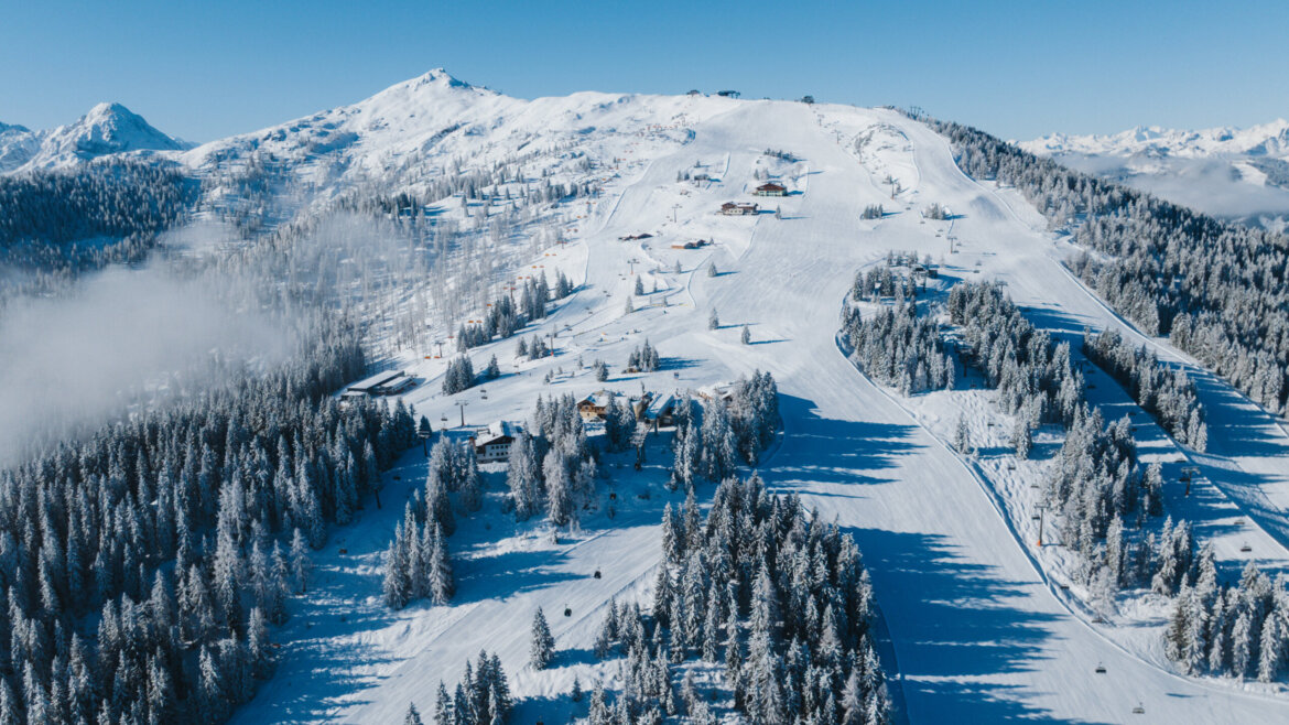Panorama lyžařské oblasti Flachau s bílými zasněženými sjezdovkami