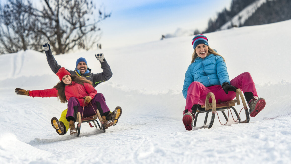Rodina sáňkuje na kopci u hostince Sattelbauer ve Flachau