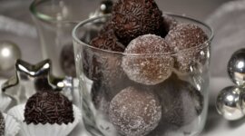 DSC_0021-001 Čokoládové kuličky obalené cukrem a posypané ve skleněné míse, se slavnostními dekoracemi poblíž.