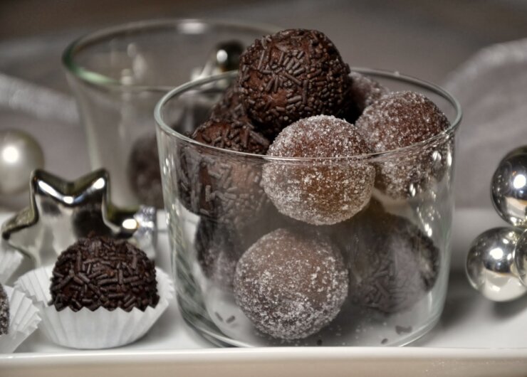DSC_0021-001 Čokoládové kuličky obalené cukrem a posypané ve skleněné míse, se slavnostními dekoracemi poblíž.