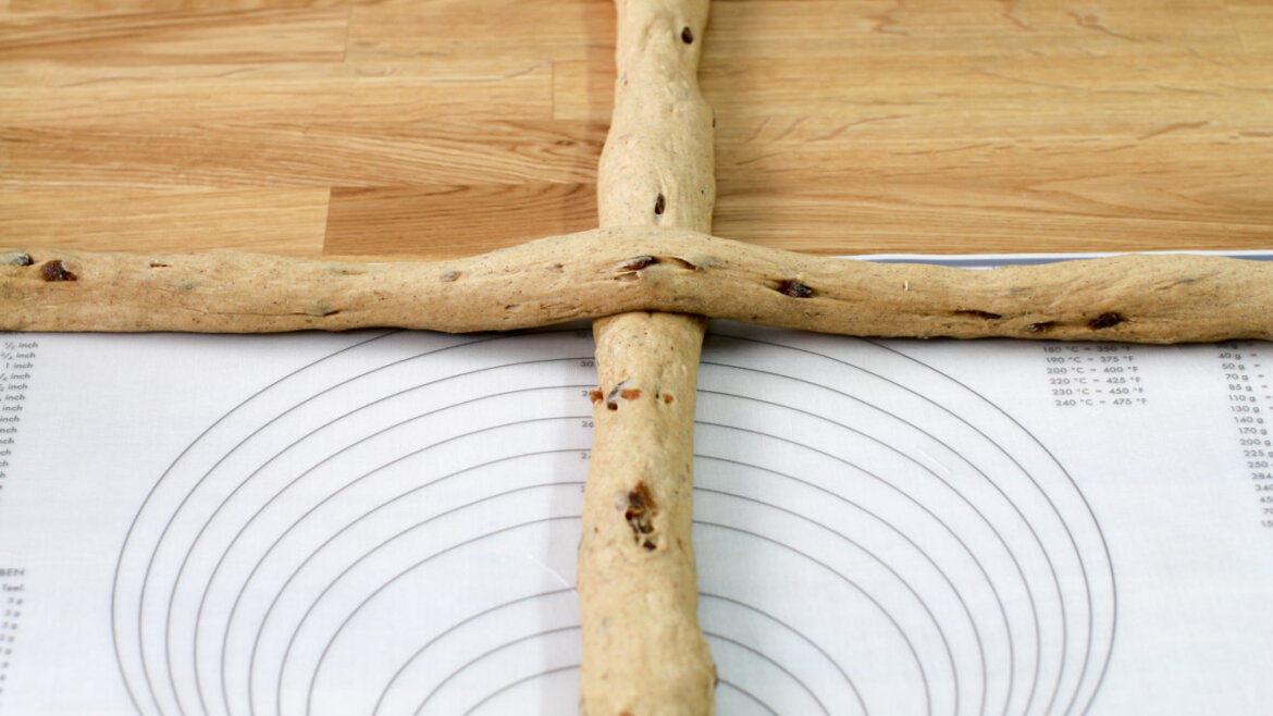 Dva kusy těsta s ovocem se zkříží na podložce na pečení se soustřednými kruhy.