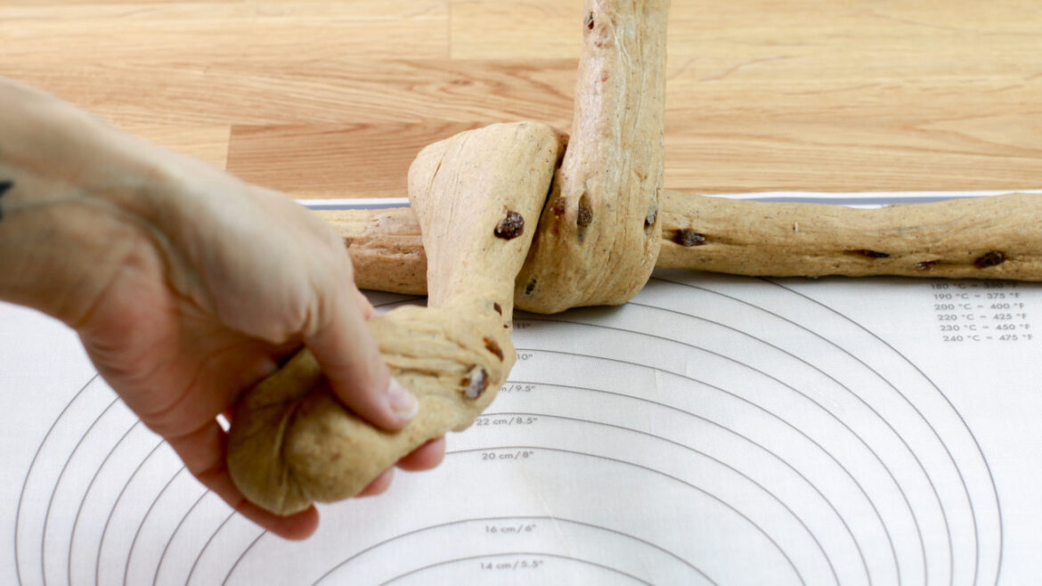 © Anke Eder Ruční pletení dvou provazů z rozinkového těsta na kruhové měřicí podložce. (Zvětšený pohled)