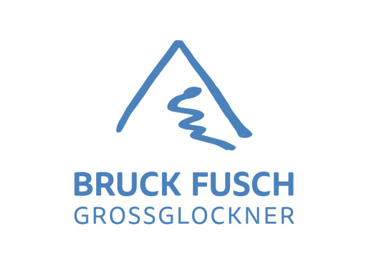 Modrý obrys hory s klikatící se cestou a nápisem BRUCK FUSCH GROSSGLOCKNER pod ním.