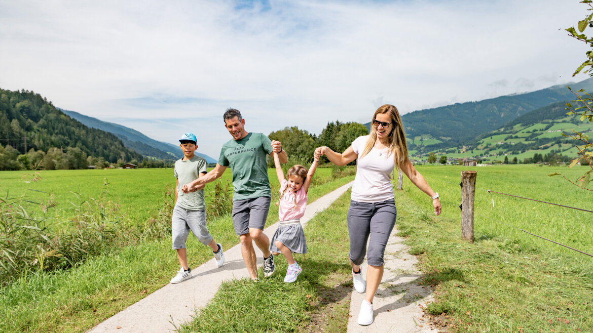 Rodina tráví čas v přírodě v oblasti Piesendorf a Niedernsill, děti si hrají a objevují okolní krajinu (Zvětšený pohled)