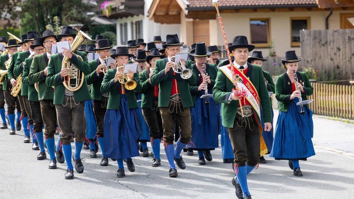 Hudební skupina vystupující na Strudelfestu v Mittersillu před návštěvníky (Zvětšený pohled)