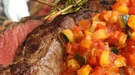 Steak propečený na „medium-rare“ s přílohou nakrájené zeleniny v rajčatové omáčce, podávaný na talíři s modrobílým vzorem.