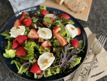 Salat m Erdbeeren©SAM-Marion Riepler.JPEG Letní salát s jahodami, kozím sýrem, vlašskými ořechy a míchaným salátem, v pozadí je nakrájený chléb.