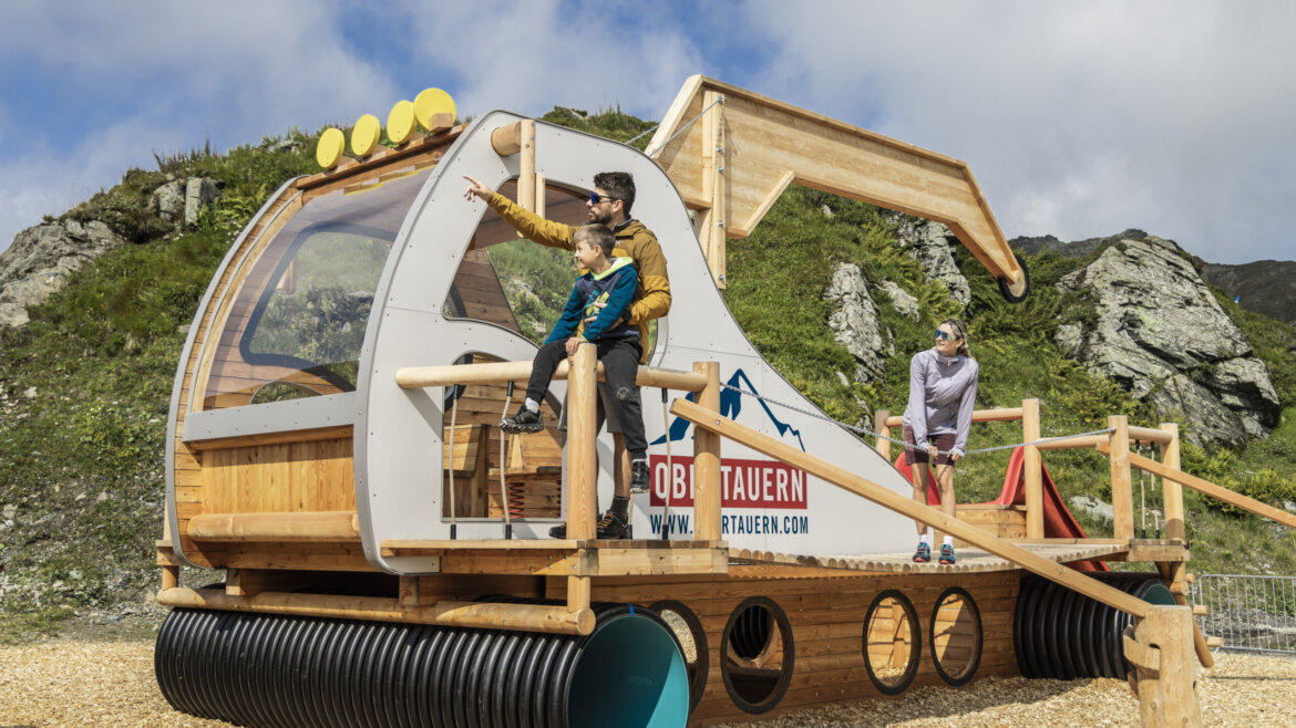 To børn og en voksen leger på en bilformet legeplads og drømmer om at stå på ski i Obertauern. (Forstørret visning)