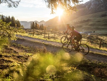Et par mennesker cykler på en sti og nyder landskabet, hvor andre måske står på ski om vinteren.