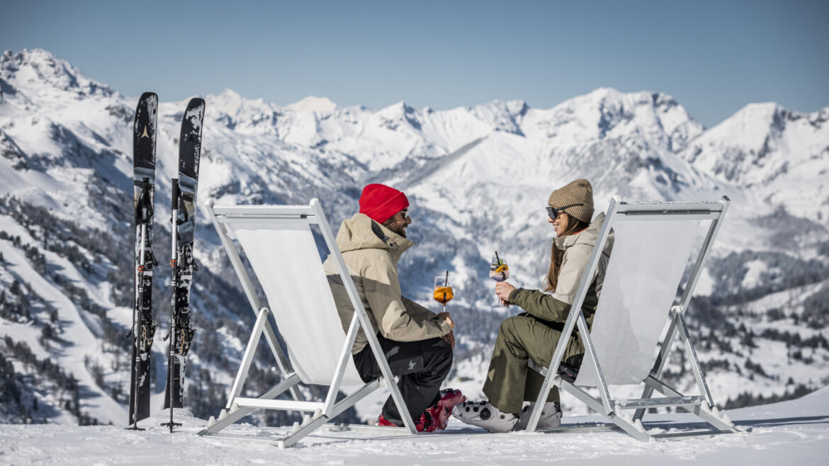 www.MirjaGeh.com, Mirja Geh To personer slapper af i liggestole på sneklædte bjerge efter at have stået på ski i Obertauern, med drinks i hånden og ski i nærheden. (Forstørret visning)
