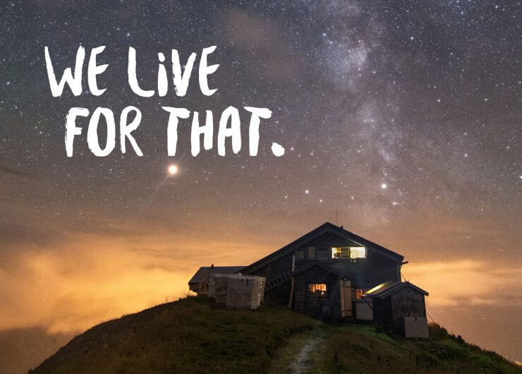 Et hus på en bakke under en stjerneklar himmel med teksten WE LIVE FOR THAT. skrevet ovenover.