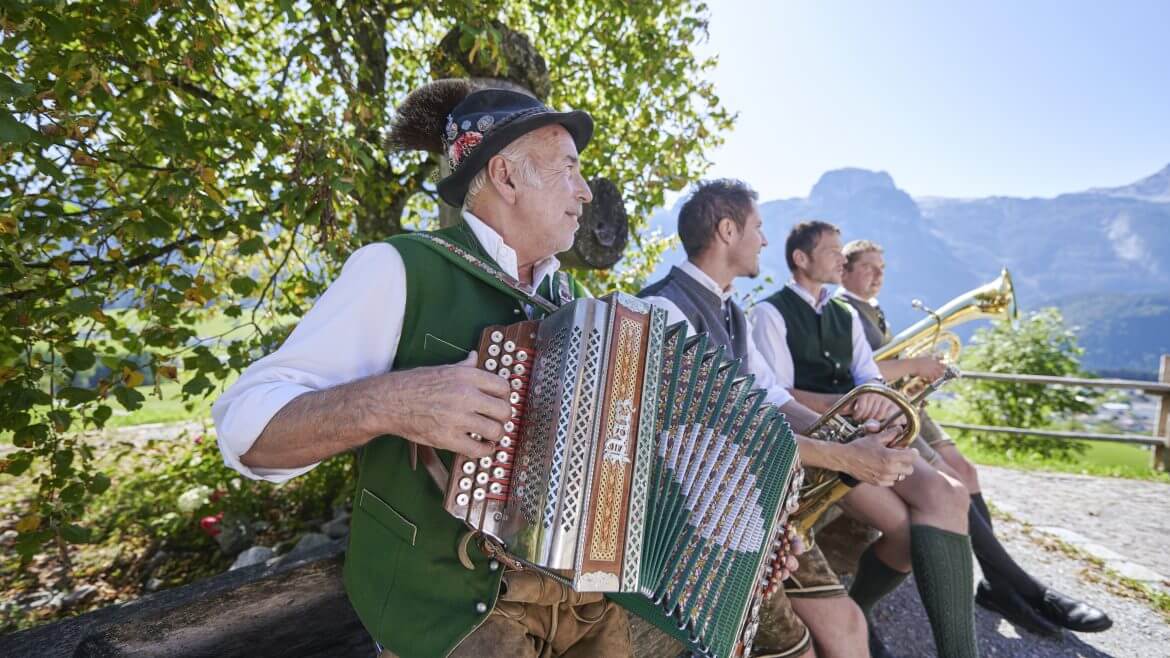 © SalzburgerLand Tourismus, Edward Groeger, Bauernherbst Vier Männer in traditioneller österreichischer Kleidung spielen auf einem Bauernherbstfest in den Bergen Volksinstrumente. (vergrößerte Ansicht)
