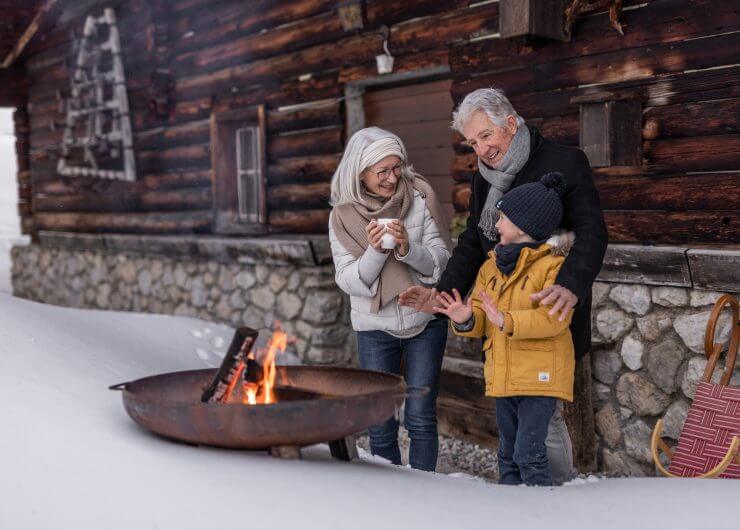 Oma und Opa mit Enkel, Generationen Wintertag in Filzmoos (c)SLTG, Aufwärmen vor der Hütte
