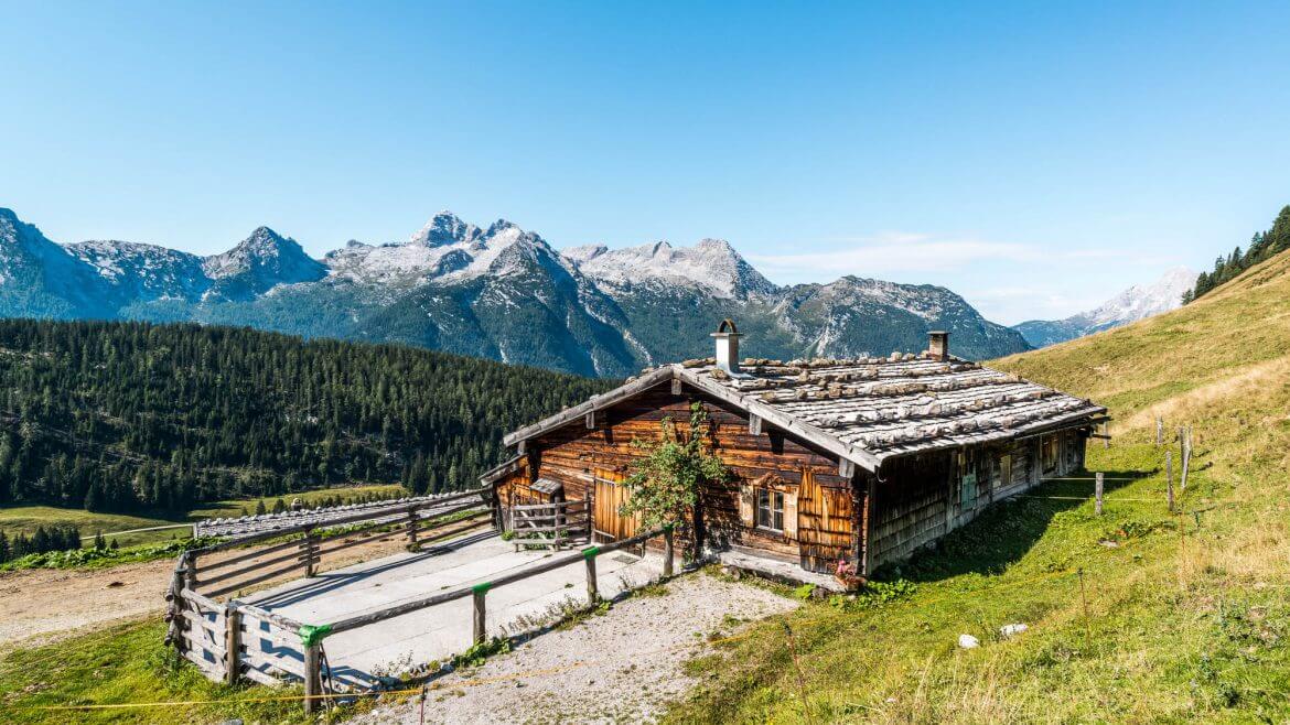 Pärchen sitzt vor der Almhütte.