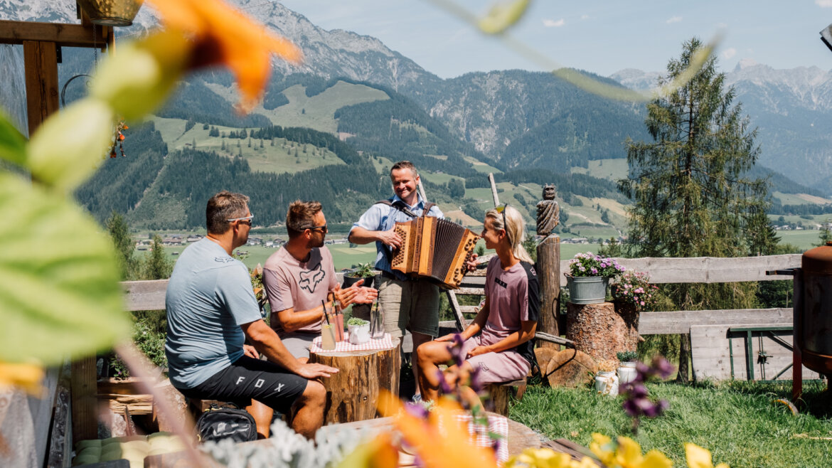 Im Rahmen der e-Bike Genusstour wird bei der Sinnlehenalm Halt gemacht. Hier warten nicht nur kulinarsiche Schmankerl, sondern auch musikalische Unterhaltung.