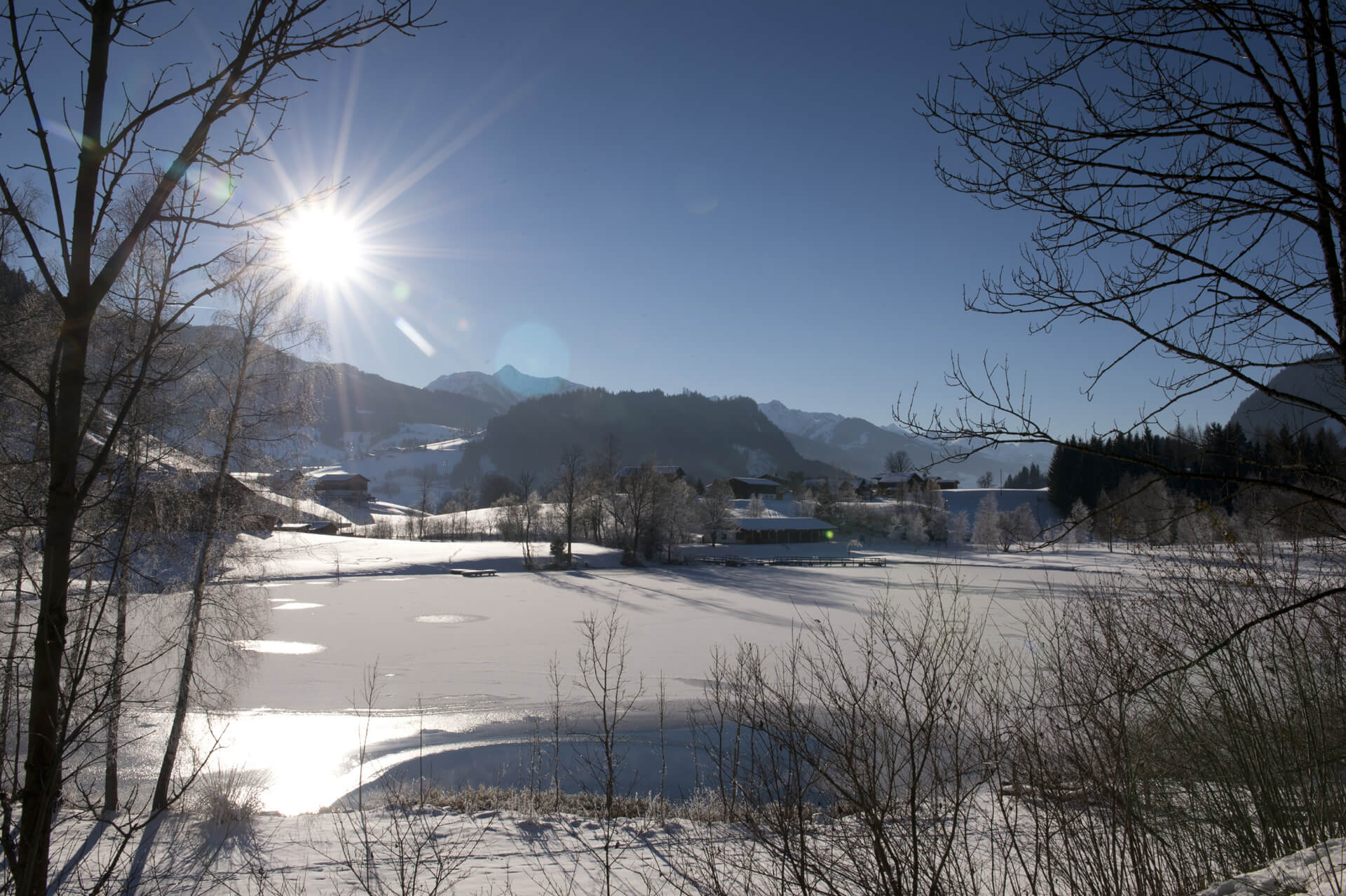 Zugefrorener Böndlsee in Goldegg im Sonnenschein