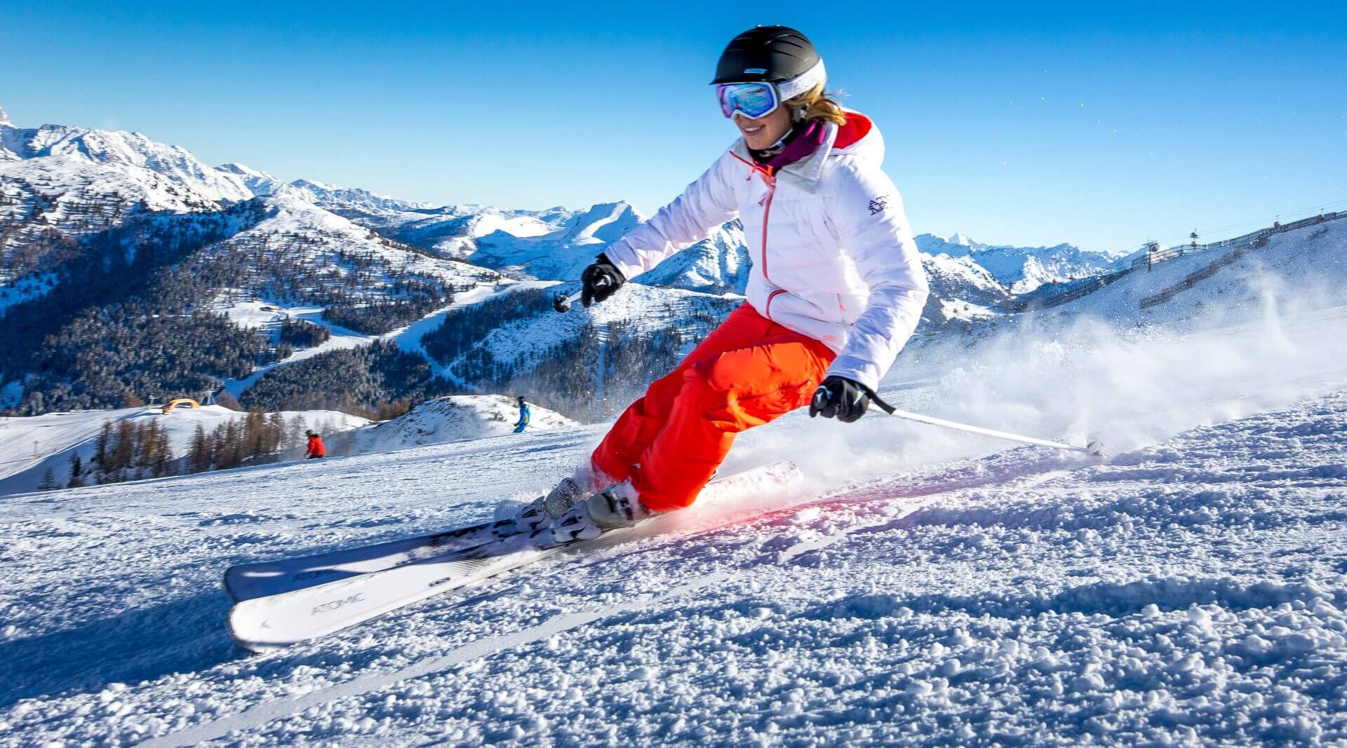 Skifahrer auf der Piste bei Sonnenschein