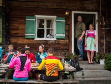 Gäste vor der Almhütte mit Wirt