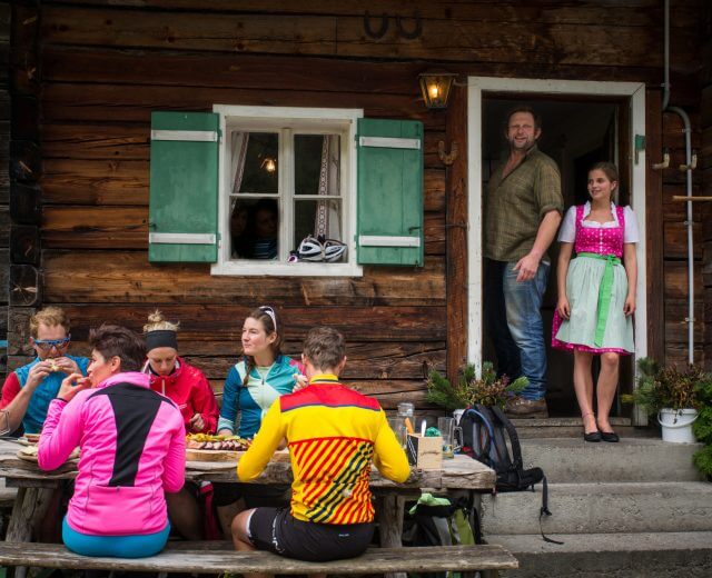 Gäste vor der Almhütte mit Wirt
